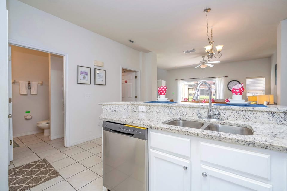 Open-concept convenience: chat at the dual-sink breakfast bar with views to the sunny living area and quick access to the main-floor bath.