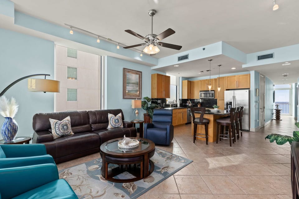 A warm, open living space that blends seating and kitchen areas with an easy, relaxed flow. Soft tones, natural light, and simple décor create a welcoming atmosphere that feels balanced and comfortable, making it an inviting spot to unwind together.