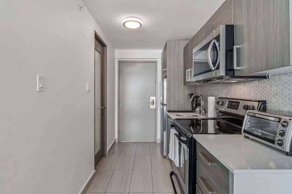 The centerpiece is the stainless steel stove with a microwave mounted above it. 