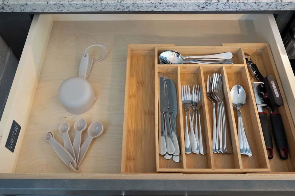 Essential kitchen tools used for preparing and serving food, including items like spoons, forks, knives, and spatulas.