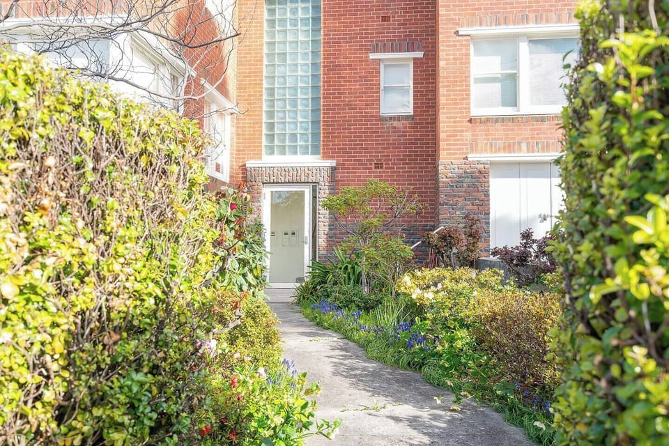 Step into a classic red-brick entry with leafy surrounds, just moments from the beach and local cafés.