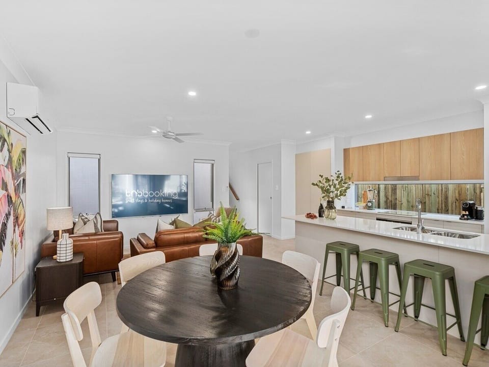 Indoor dining sits near the kitchen with a six-seat table and breakfast bar.