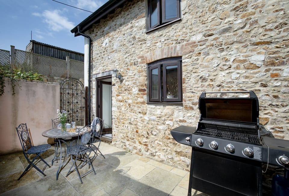 The Old Shippon, near Honiton. Outside: The bright patio area offers a welcoming barbecue spotÃ¢â‚¬â€perfect for enjoying summer evenings with a drink in hand, or unwinding in the tranquil outdoor setting