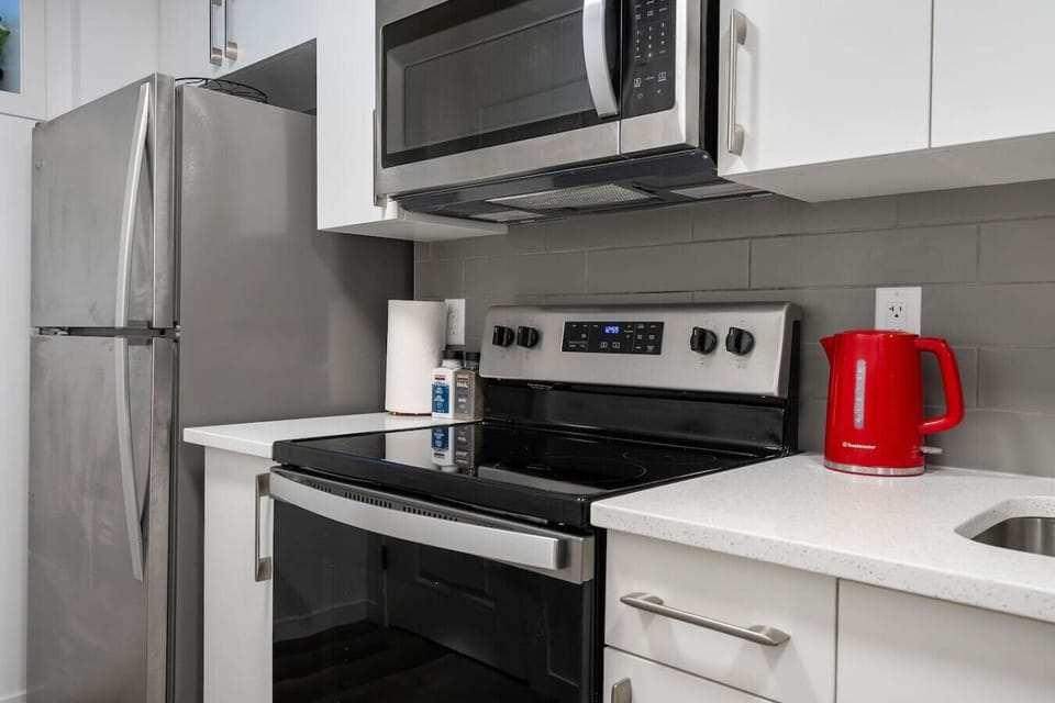 Well-appointed kitchen featuring stainless steel appliances and white quartz countertops