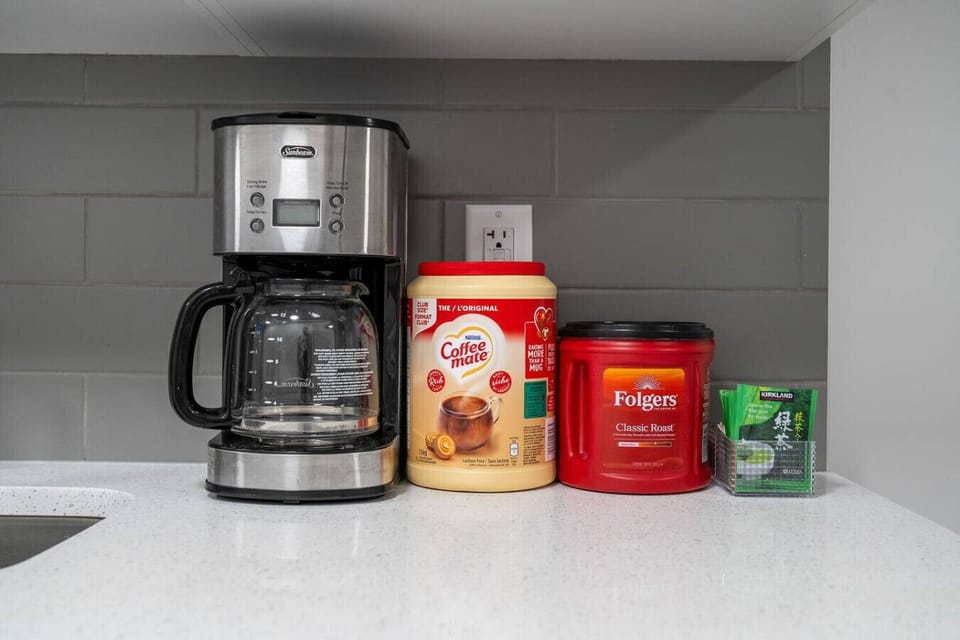 Kitchen counter with coffee maker and assorted coffee supplies