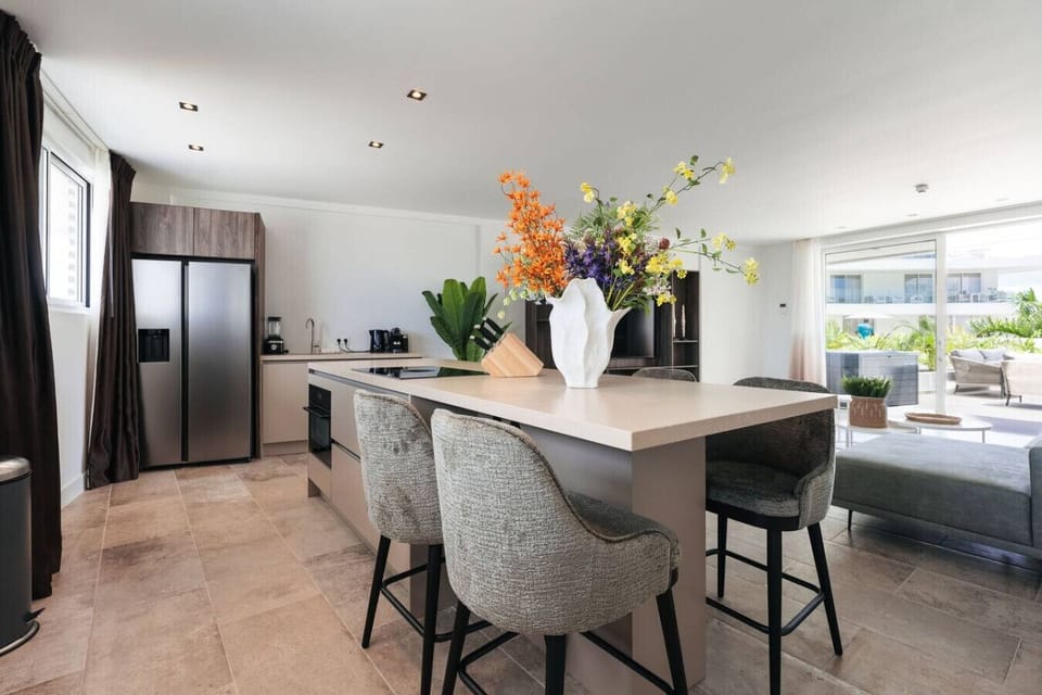 Start your mornings here—fresh coffee in a sleek modern kitchen, sunlight streaming in, and an island perfect for breakfast chats before heading out to explore.
