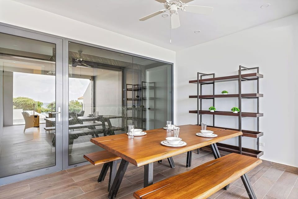 Gather around this beautifully crafted dining table, where modern design meets warm wood tones—your perfect spot for shared meals and conversation with a seamless flow to the outdoor terrace.