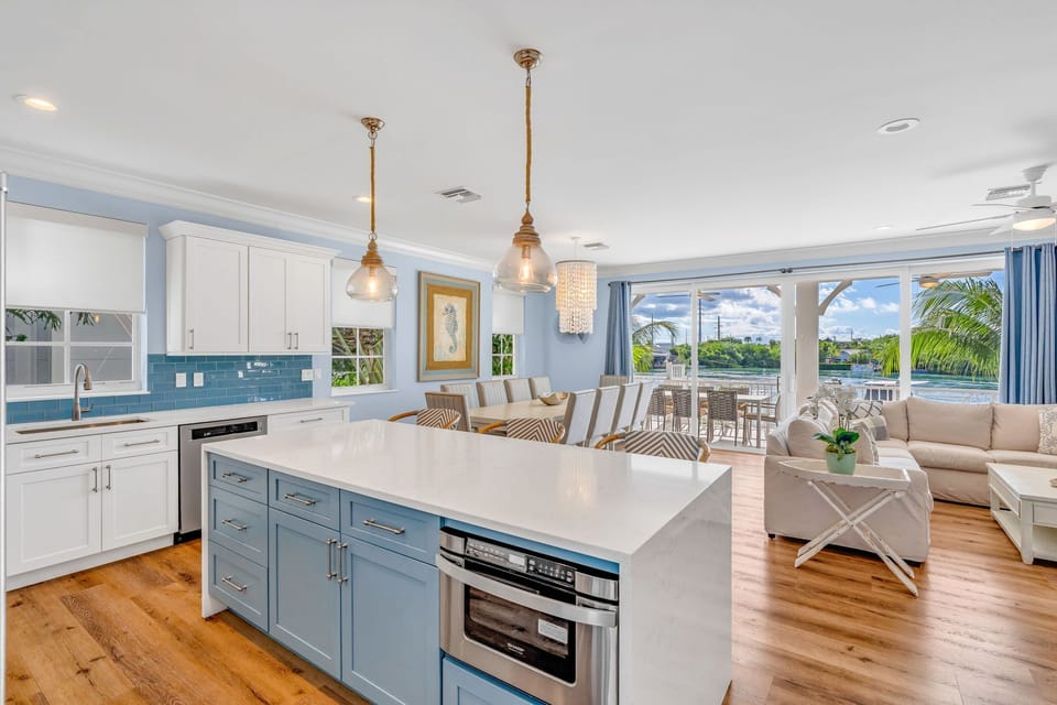 Prepare meals with panoramic Gulf and Atlantic views in this luxury Marathon FL vacation home kitchen, featuring a fully stocked pantry, high-end appliances, and island seating.