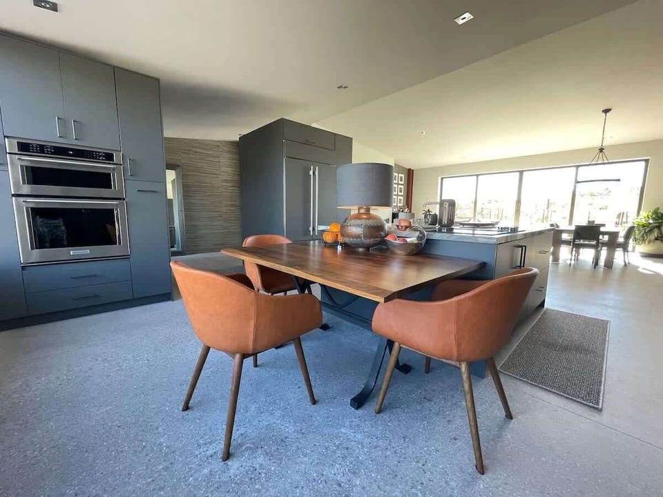 Estate 1: Fully equipped luxury kitchen stocked with all culinary essentials and features high-end stainless-steel appliances, a kitchen island, a breakfast table, and a wet bar / coffee station.