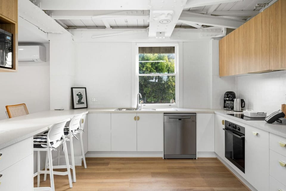Enjoy a well-stocked kitchen with coffee machine, oven, and casual bar seating—perfect for easy meals before a beach day.