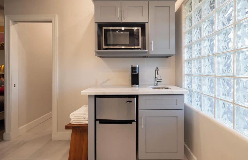 Kitchenette with microwave, coffee maker, mini fridge, and freezer. 