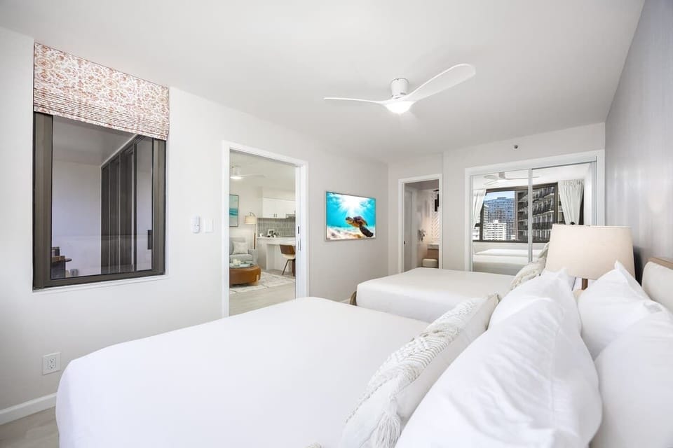 Relax in the bedroom, featuring 2 cozy queen beds and convenient access to a private bathroom.
