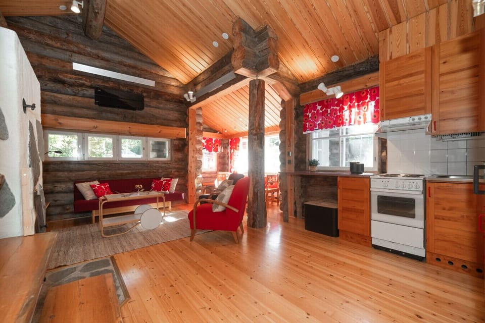 The open living space combines a fully equipped kitchen—with fridge, oven, stove, microwave, and dishwasher—and a dining table for six.