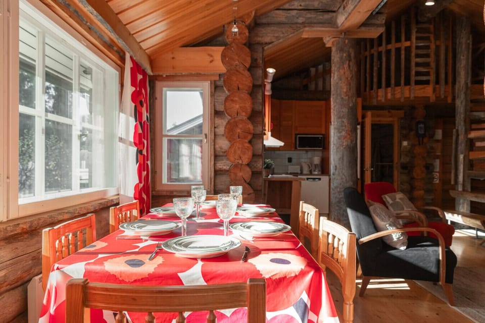The open living space combines a fully equipped kitchen—with fridge, oven, stove, microwave, and dishwasher—and a dining table for six.