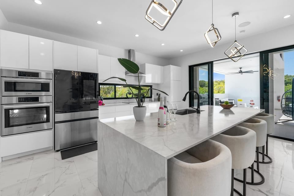 Modern kitchen with a marble island and bar seating.
