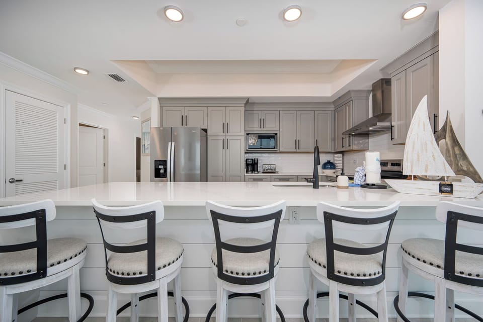 Gather around the stylish breakfast bar, perfect for casual meals and conversations in this inviting kitchen space
