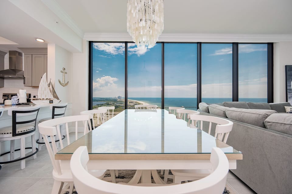 Dine at the elegant table with expansive views through large windows, perfect for family meals or game night