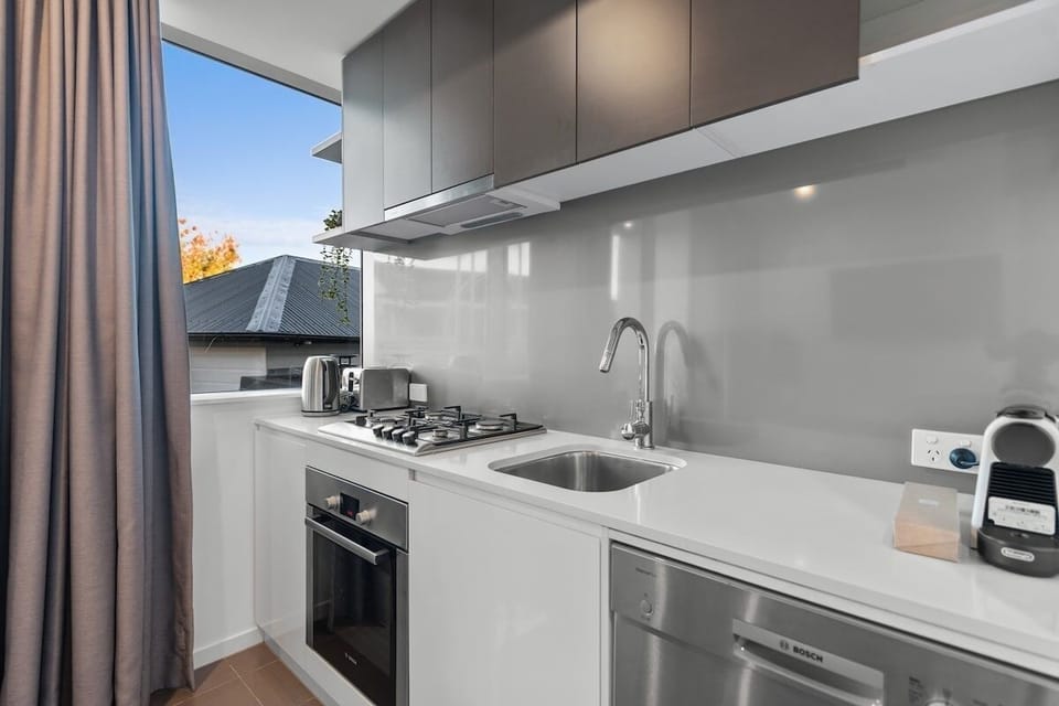 Open kitchen connects with living and dining for an easy apartment layout.