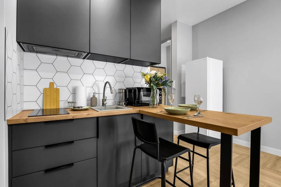 Modern Kitchen Area – Fully equipped with stove, microwave, kettle, and dining bar for two | Book Now with RENTUJEMY.COM