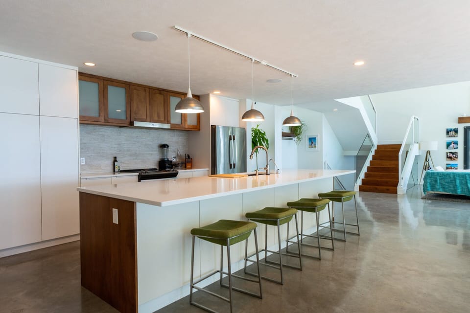 🍽️ Sleek, social, and sunlit. Polished concrete, warm wood, and cozy seating—perfect for cooking, gathering, or just vibing.