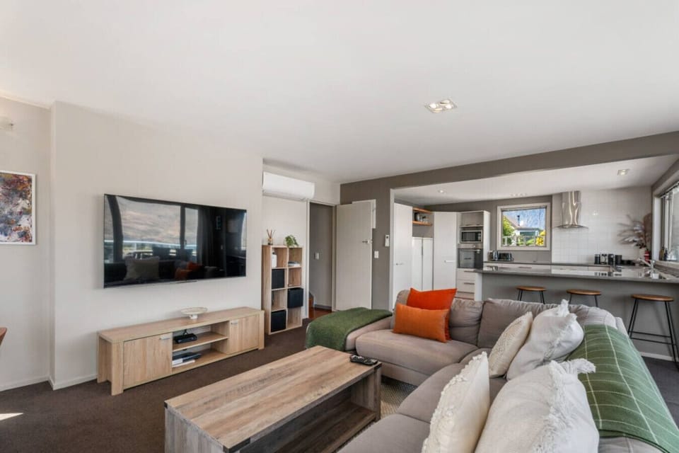 Open-plan living area with comfy seating and smart TV