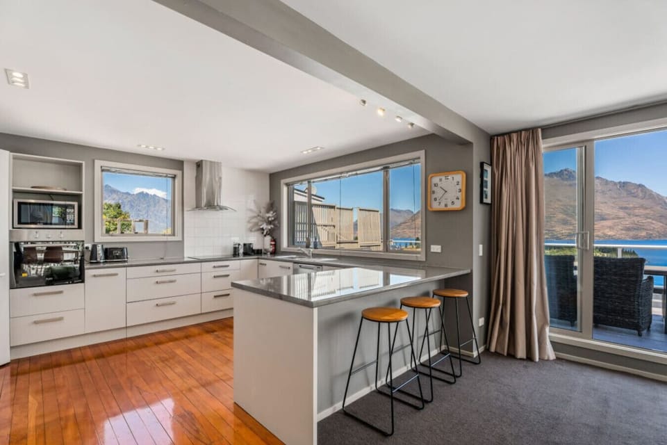 Modern fully equipped kitchen with breakfast bar and stunning lake views from every angle
