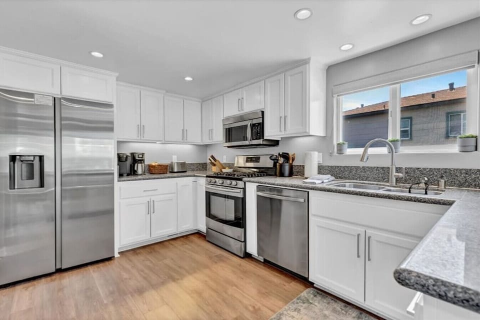 Second Floor: kitchen with stainless steel appliances, dining area, and balcony views.