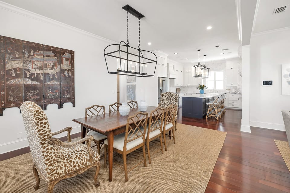 Dining room open to kitchen with iron chandelier
