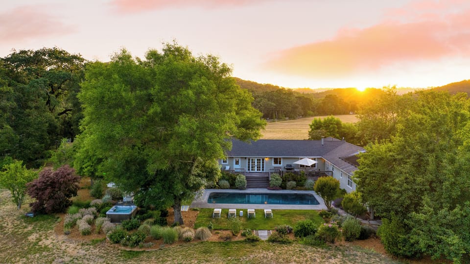 Aerial twilight view showing the home, pool, and full grounds.