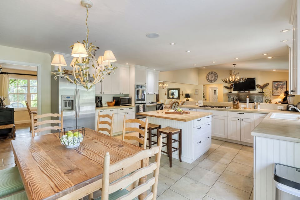 Open kitchen & dining combo with island seating and garden views.