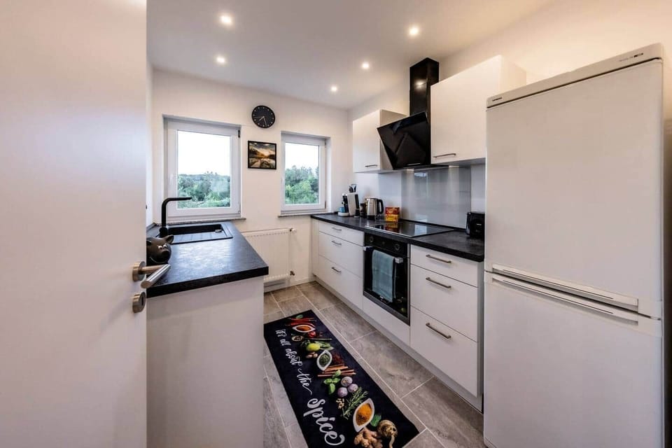 Fully equipped kitchen with modern ceramic hob, oven and extractor hood