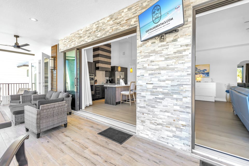 Balcony with TV and lounging just outside kitchen area.