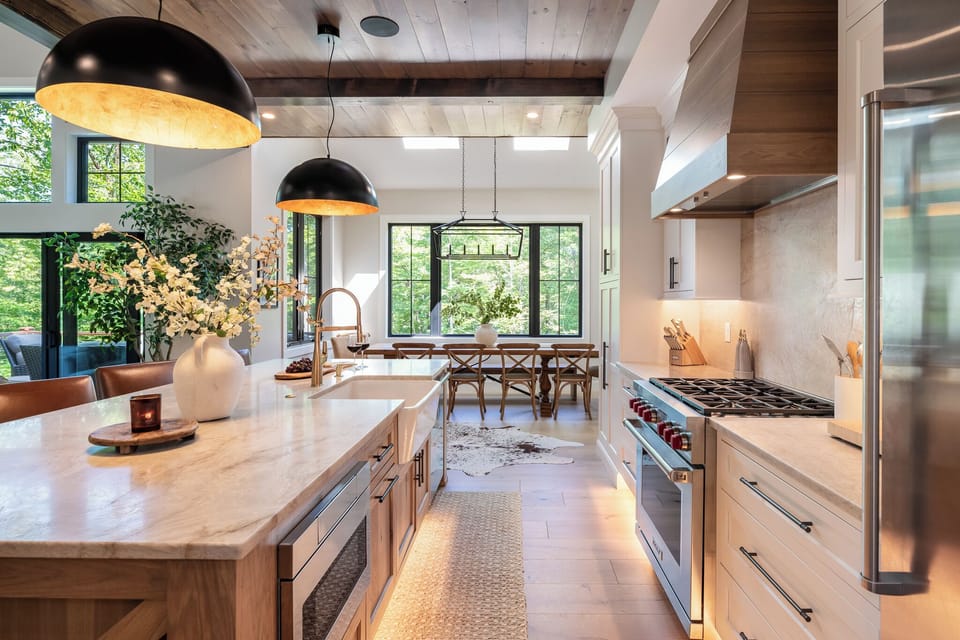 Bright gourmet kitchen with a large island, high-end appliances, and farmhouse sink. Opens to the dining area with big windows and natural light, creating the perfect space for cooking and gathering.