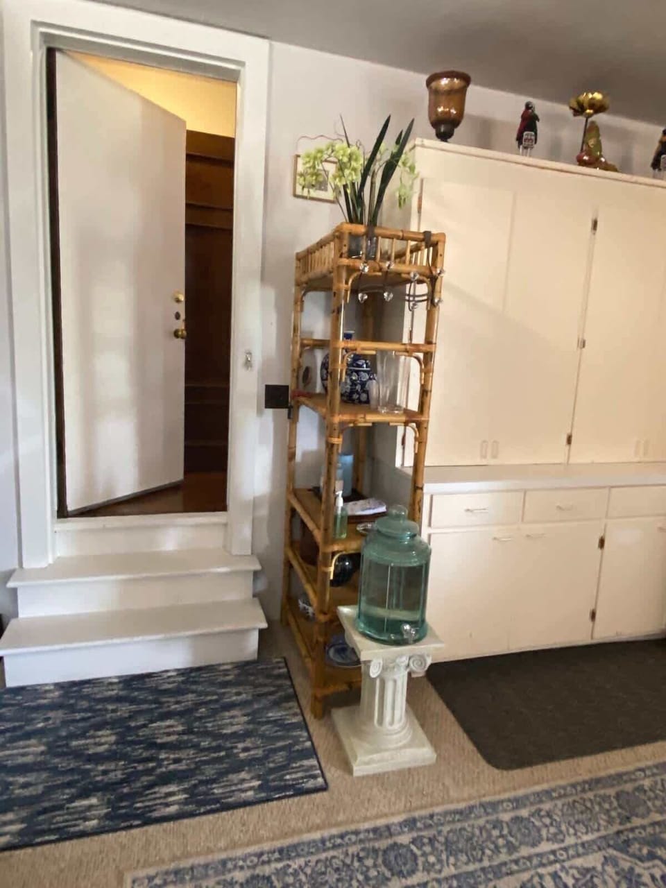 Bright interior corner with decorative shelving and easy access to the bathroom.