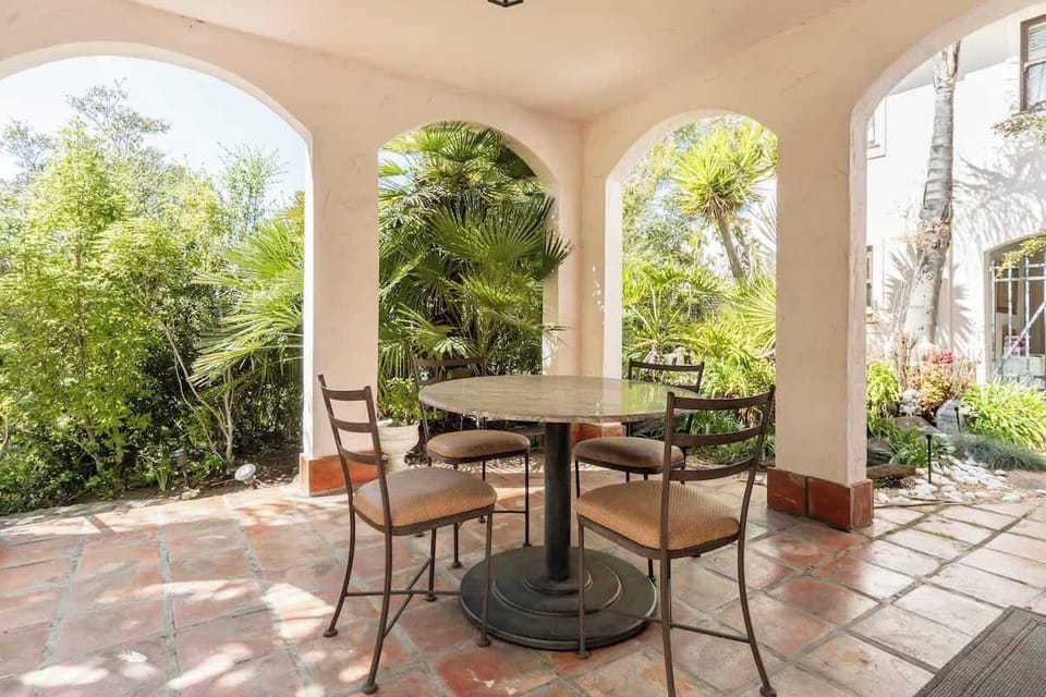 Relax on the shaded patio surrounded by lush greenery, a peaceful spot for morning coffee or a quiet afternoon break.