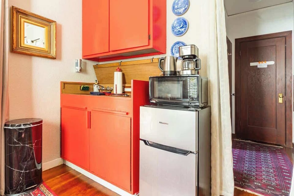Convenient kitchenette featuring modern appliances and vibrant cabinets, giving you everything you need for light cooking.
