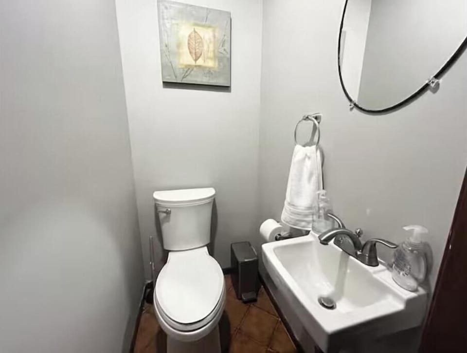 Fully equipped bathroom with great lighting and a charming mirror.