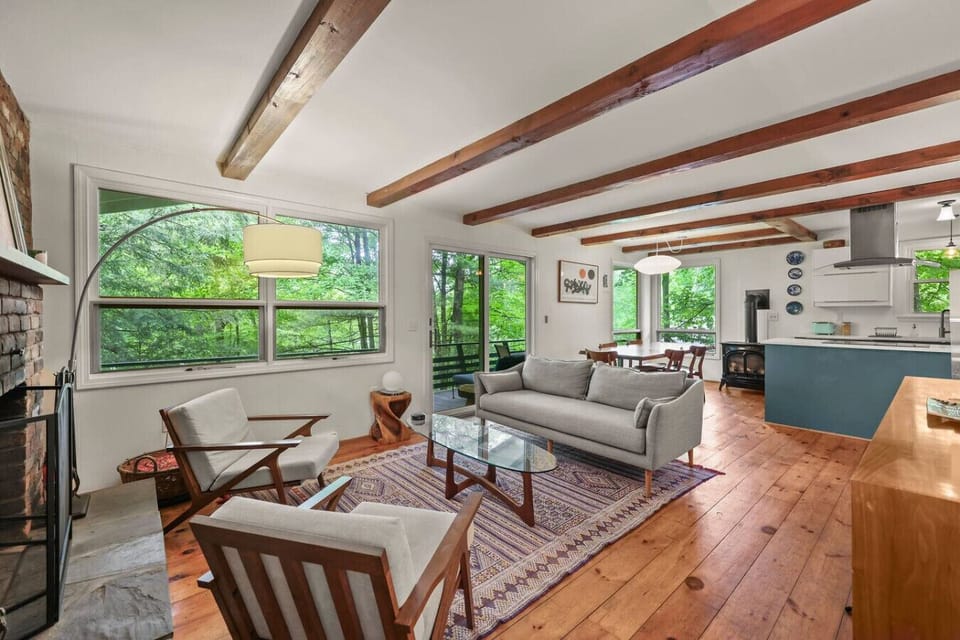 Cozy seating area with fireplace and large windows overlooking greenery.