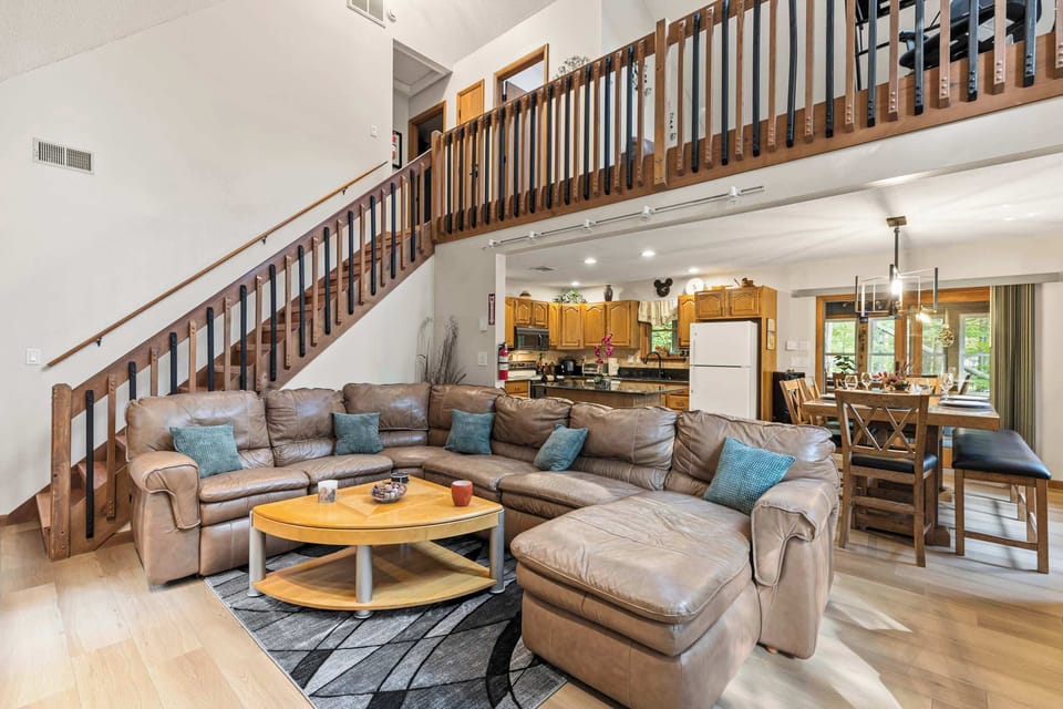 Gather without crowding. Oversized leather sectional beneath the loft, ideal for multi-family trips, work retreats, and game nights in Lake Ariel.