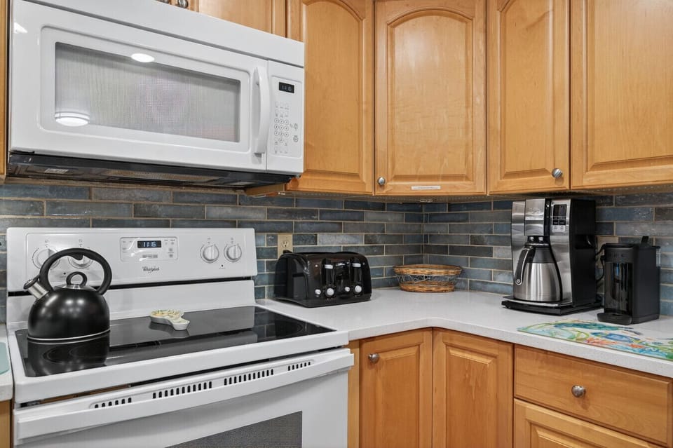 Kitchen cooktop & oven framed by warm wood cabinets and easy-to-clean counters.