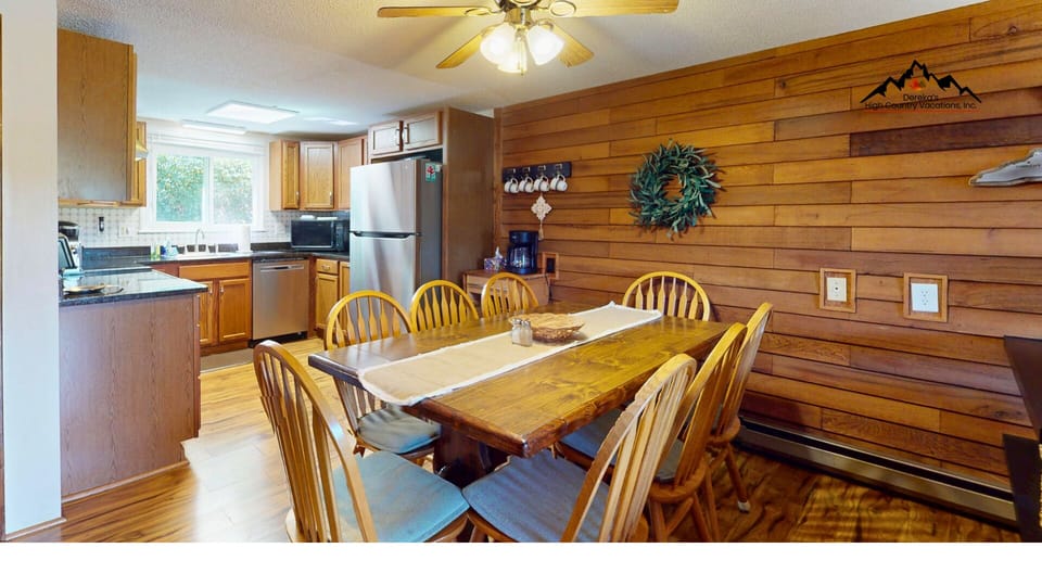 Spacious dining area with seating for group meals and easy flow into the kitchen and living room, perfect for gathering and entertaining.