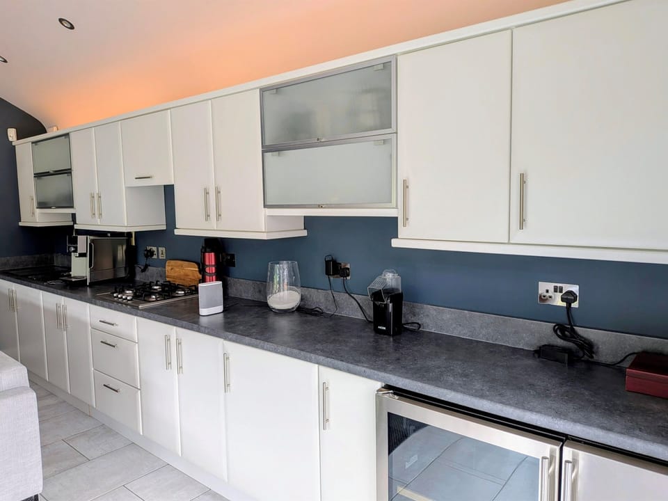 Second kitchen. Sink, gas hob, wine fridge, fridge and ice machine. Seating and eating areas indoor and out.