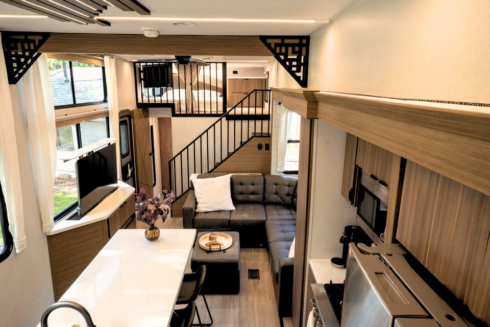 Modern comfort with cozy sofa, big windows, and a hidden pop out TV surprise
