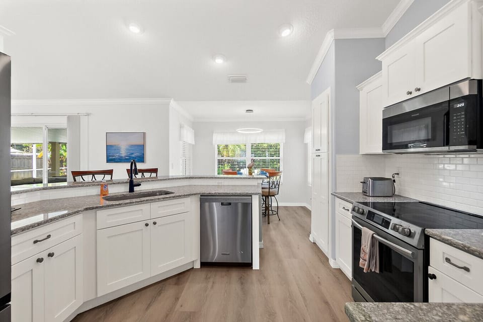 Spacious kitchen with granite countertops, breakfast bar seating, and an open layout flowing into the dining area with plenty of natural light.