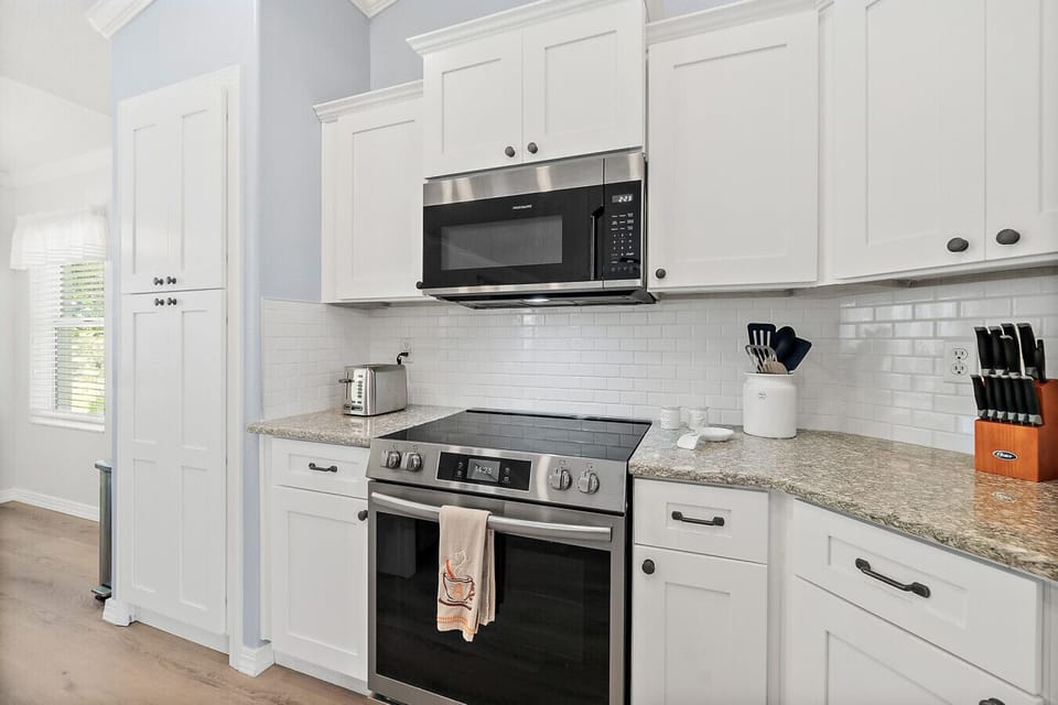 Fully equipped kitchen with modern stainless steel appliances, granite countertops, and plenty of cabinet space for all your cooking needs.