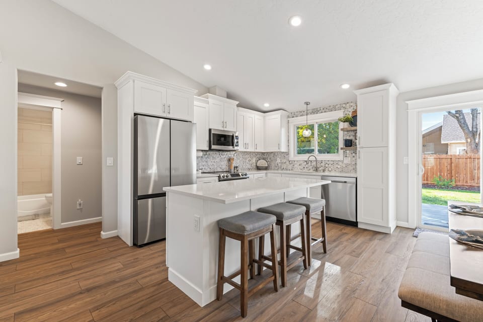View of the kitchen with bar seating for 3 and table seating for 6.