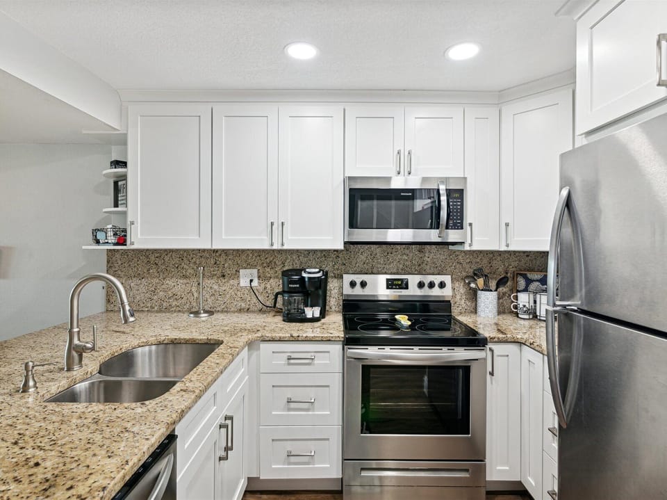 Next to the living area is a modern, fully equipped kitchen.