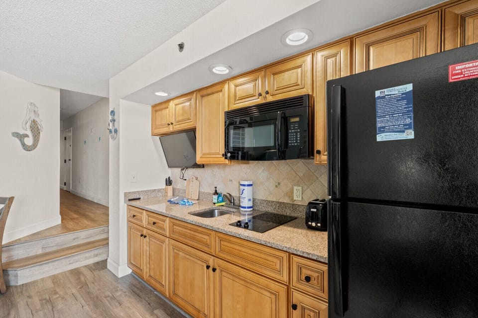 Fully equipped kitchenette with full-size refrigerator, microwave, two countertop burners, sink, and ample cabinet space. Includes Keurig and drip coffee makers, 40` Smart TV, plus stocked dinnerware, cookware, and silverware.
