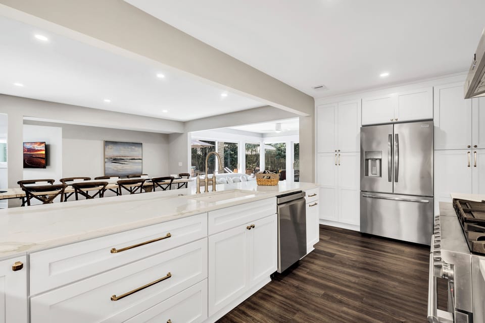 It features sleek appliances, ample counter space, a kitchen island with additional seating, and all the essentials for home chefs
