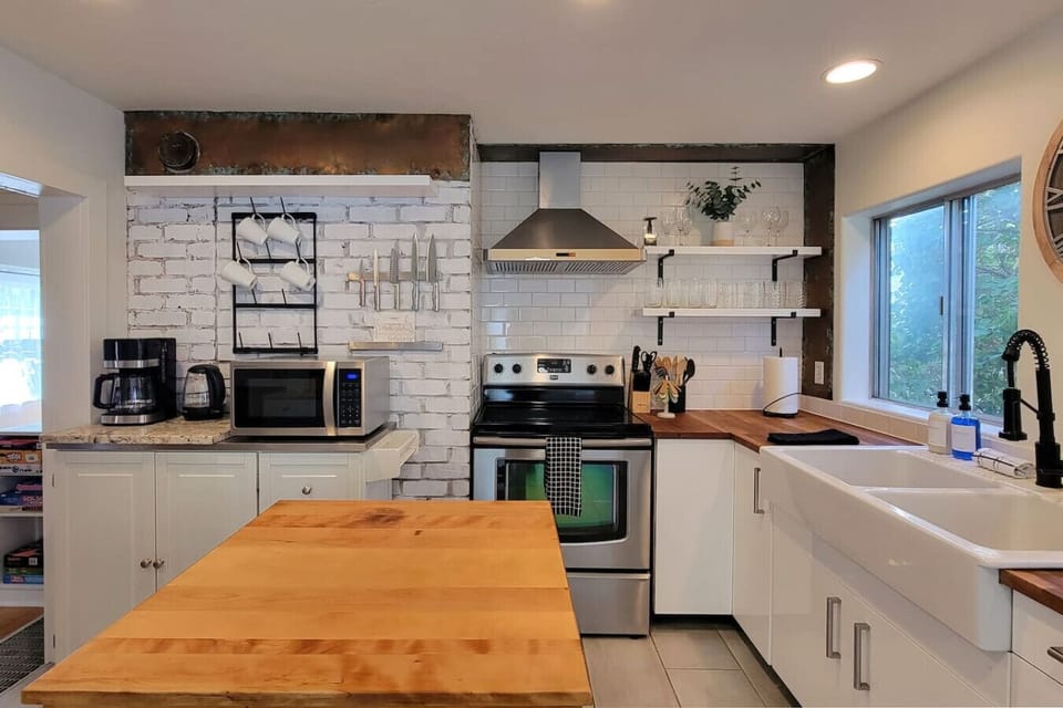 Fully equipped kitchen with electric stove, microwave, drip coffee maker, dishwasher, and more